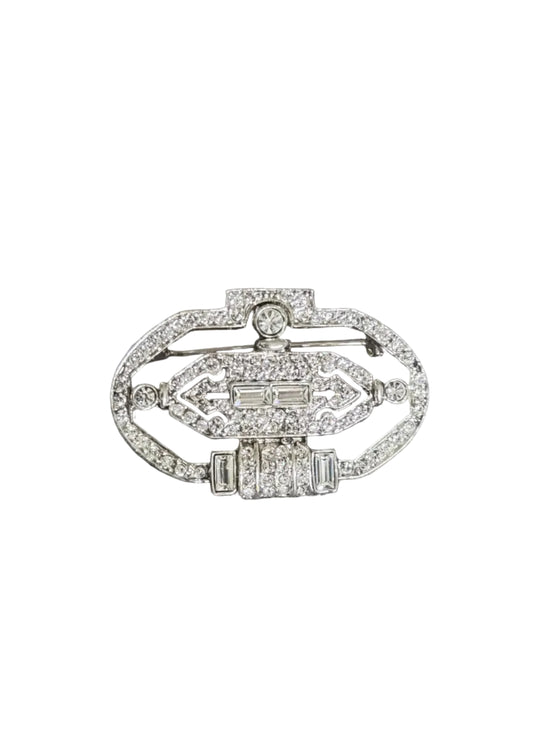 A silver-toned Art Deco style brooch with pavé-set clear stones, featuring geometric patterns and rectangular accents,