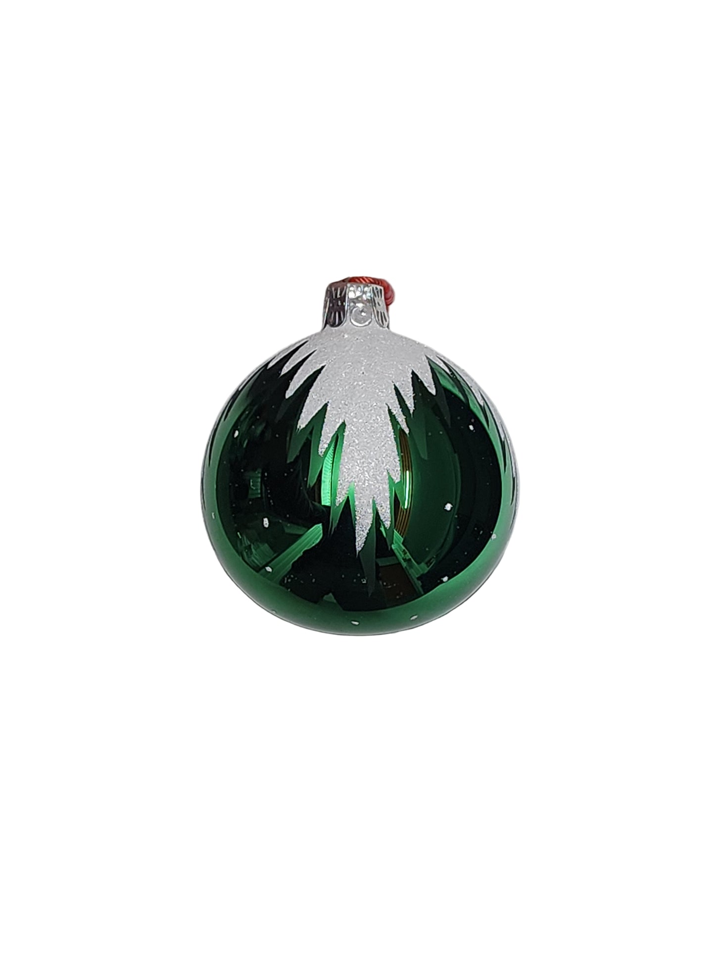 Hand holding a green glass ornament with white design on a white background