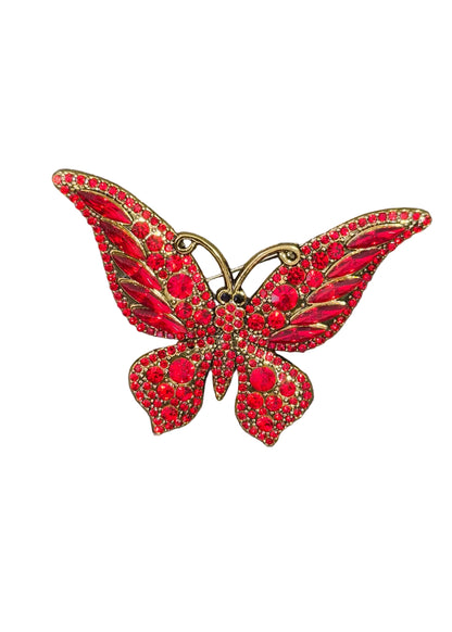 A red and gold butterfly-shaped brooch embellished with crystals.