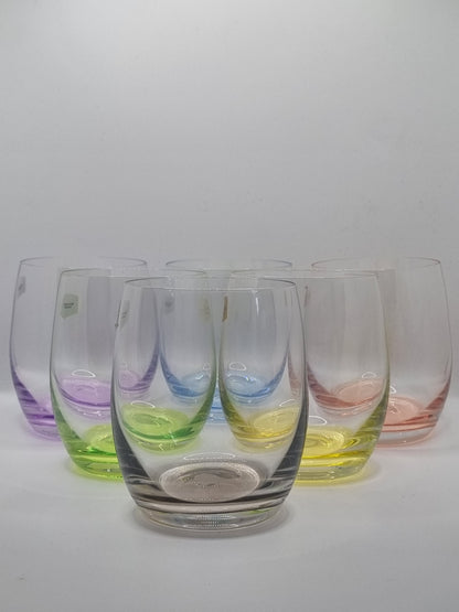 Set of colourful glass whiskey tumblers on a white background