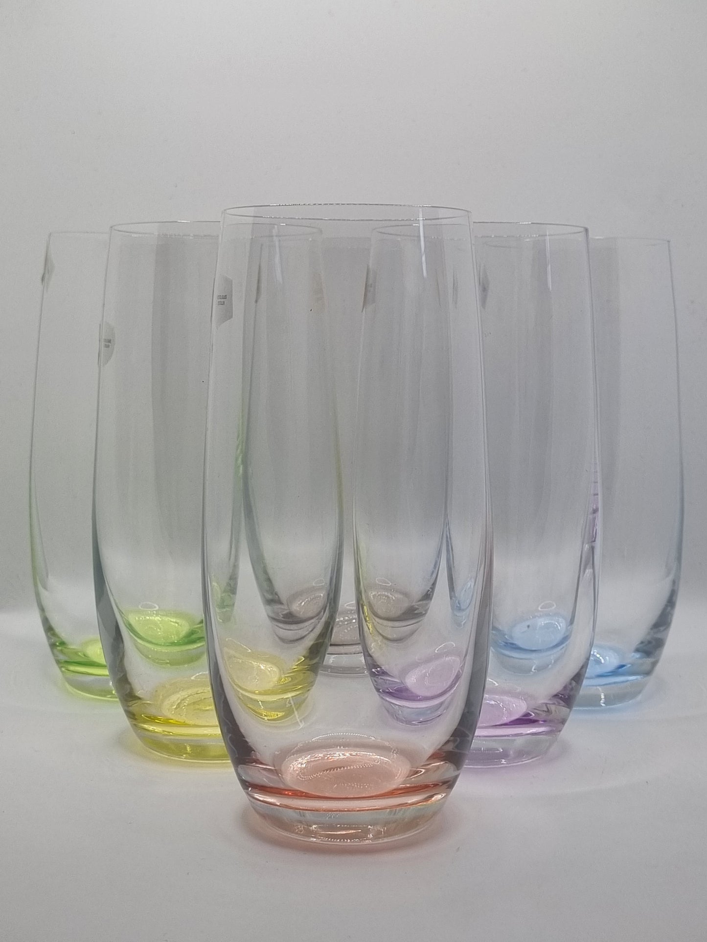 Set of colourful glass tumblers on a white background