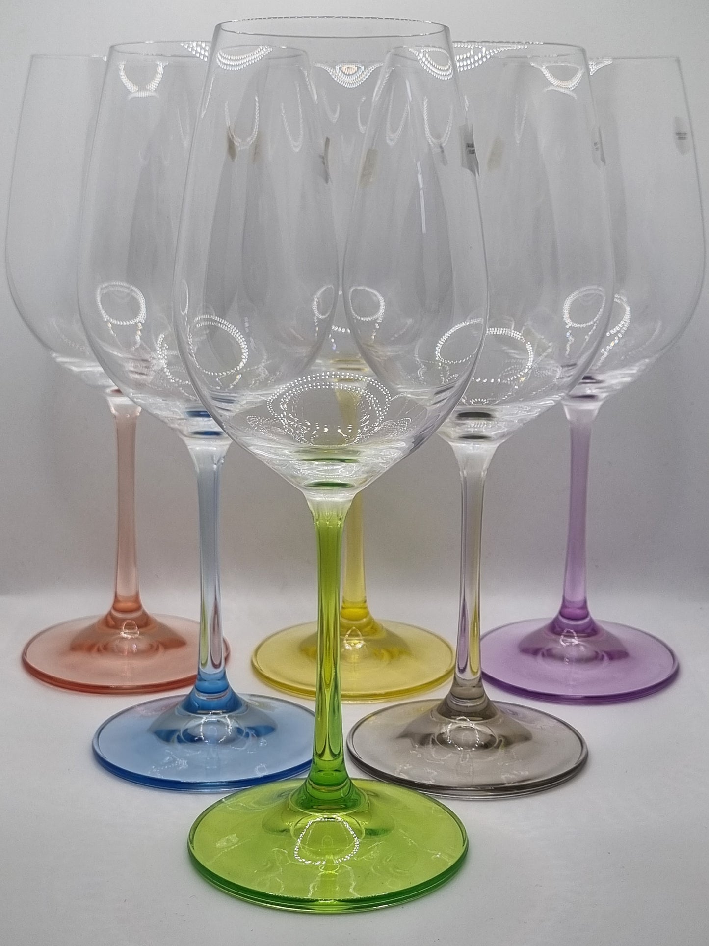 Set of colourful white wine glasses on a white background