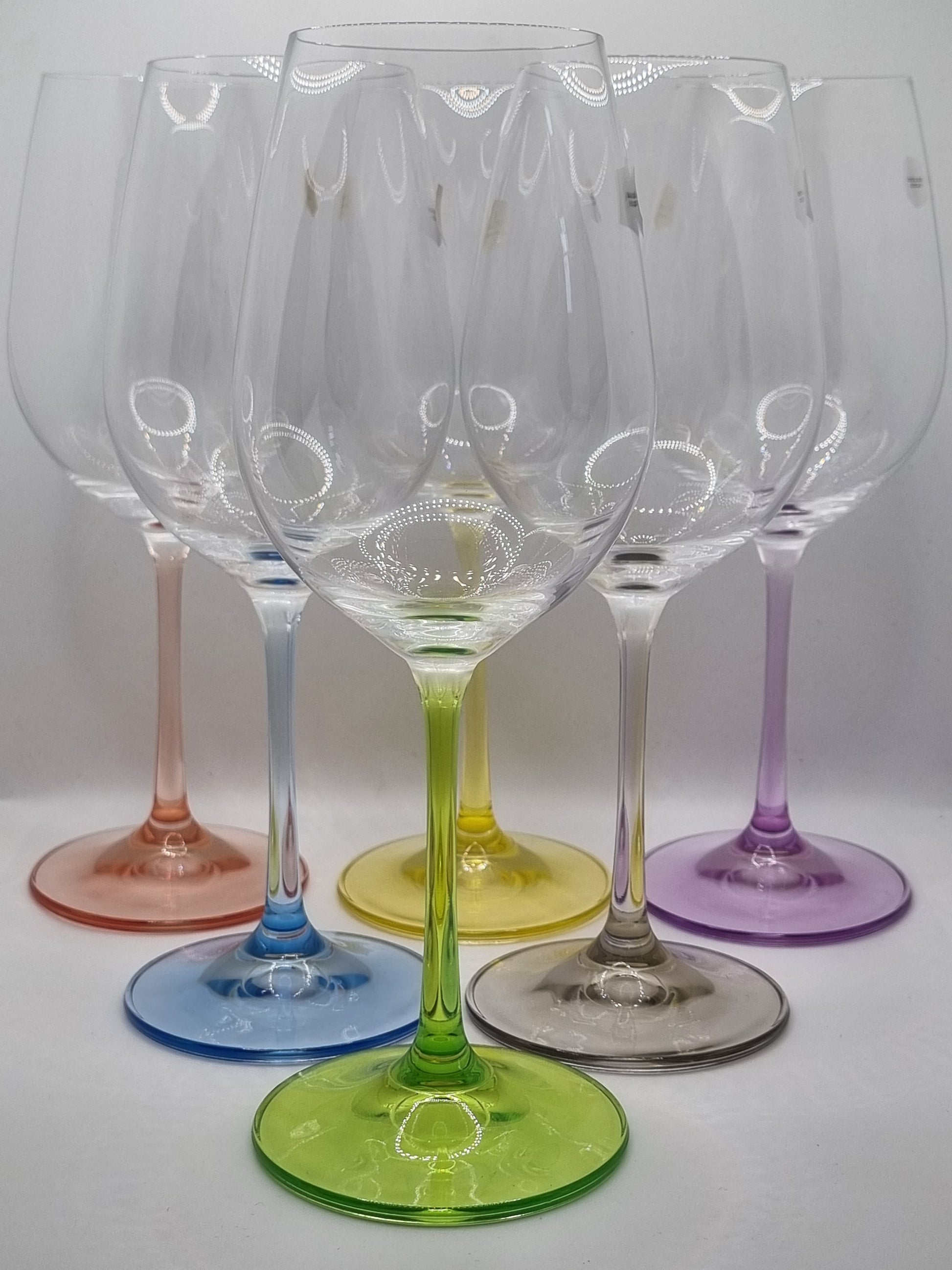 Set of colourful white wine glasses on a white background