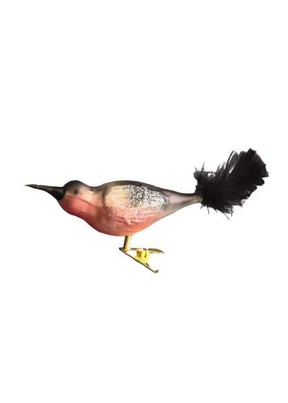 A small decorative bird figurine with a pink-red body, gray and black speckled back, black beak and tail feathers, and yellow legs.