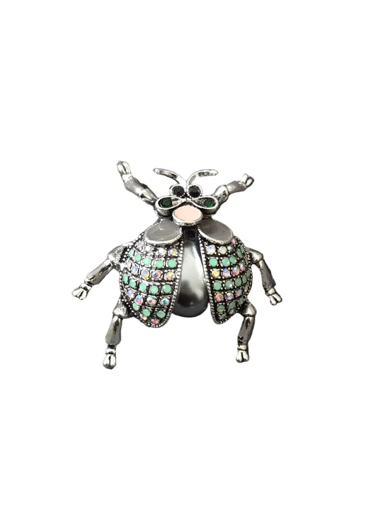 A metallic beetle-shaped brooch with green and pink rhinestone-embellished wings.