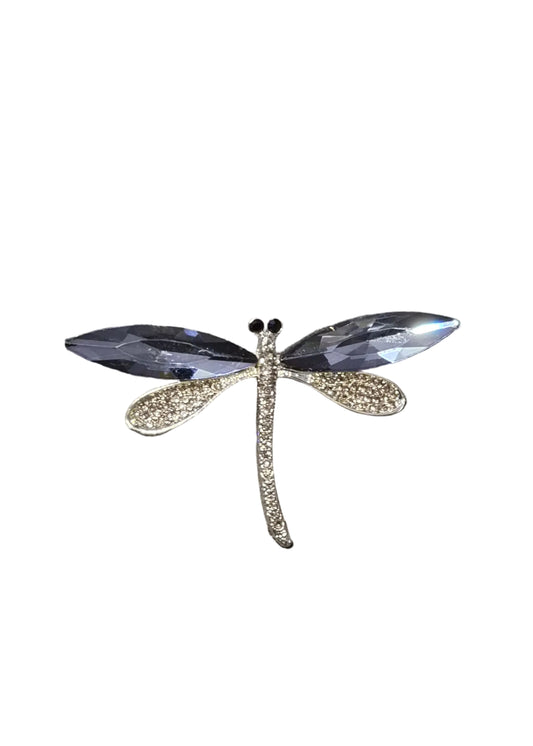 A dragonfly-shaped brooch with clear faceted wings and a textured gold body