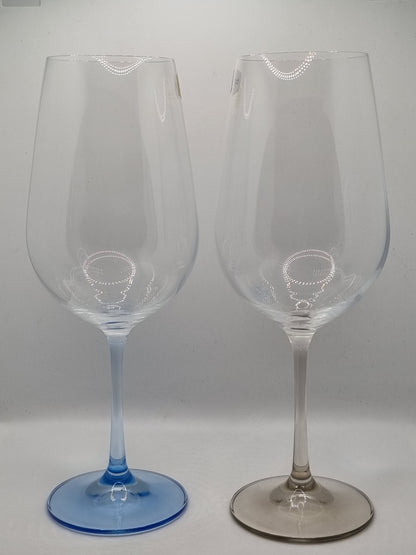 Two red wine glasses with blue and grey stems on a white background